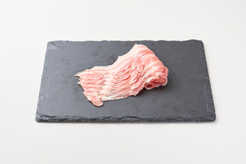 黒いお皿にのった豚バラ肉
