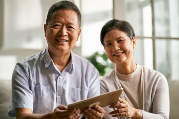 senior asian couple using digital tablet together at home