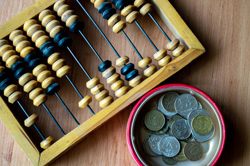 Russian currency, coins lie next to hand abacus on a wooden surface