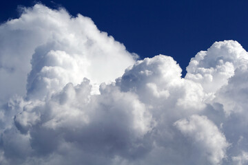 Close up of fluffy, white cumulus clouds in a bright blue sky