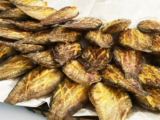 Deep fried Snakeskin gourami fish with spawns on white arches oil paper sheet