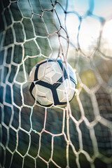 Soccer ball in goal net, scoring moment