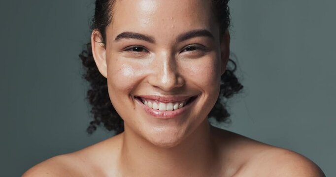 Woman, face and skincare or smile in studio, happy and acne treatment for dermatology wellness. Glowing, clean and routine transformation, background and confident for natural breakout prevention