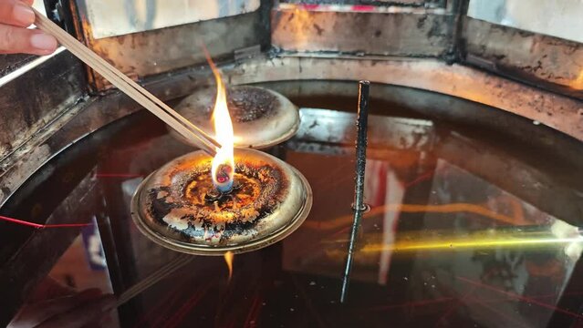 Light incense sticks from candles floating on lamp oil.