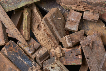 pile of scrape wood pieces with nails in full frame background, left over decayed or rotten weathered wood blocks from construction, unusable for recycling taken from above