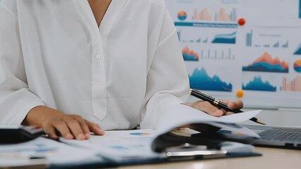 Young Business Asian woman using the tablet for doing math finance on wooden desk in office, analysis, seo, data, analyst, asian, financial, tax, accounting, Report financial document concept - Powered by Adobe