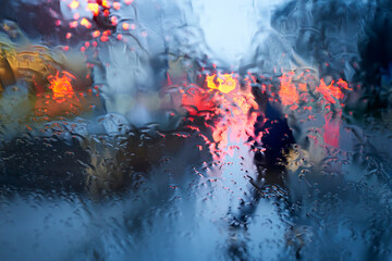 Raindrops on the windshield. Rush hour traffic in the city. Pedestrian.