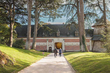 Couple walking through ancient french courtyard
