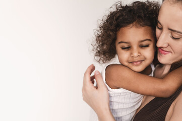 Interracial family having fun on white background. Mixed marriages concept. European mother and 2...