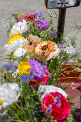 Colorful flowers in jars on a red wagon in an outdoor setting