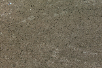 Close-up of a footprint disturbing the smooth pattern of textured sand