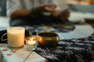 Burning candles, Tibetan singing bowl creating mystical and serene atmosphere ob fortune teller desk