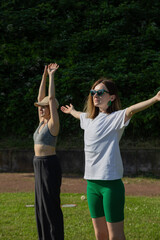 Obraz premium Two Women Stretching in a Park