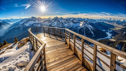  There is a wooden walkway with a railing on top of a mountain. The walkway is surrounded by snow. There are mountains in the distance. The sun is shining.