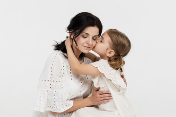 Close-up of touching and tender interaction between mother and daughter on a light background. Mom's gentle touch. Family concept.