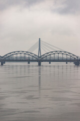 Fototapeta premium cloudy city with brigde over the river daugava