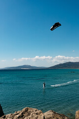 kitesurfing   Spain. Unknown kitesurfer surfing on a flat azure water of Atlantic ocean 