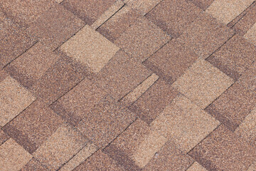 A brown shingled roof with a tan and brown color. brown roof shingle background and texture.