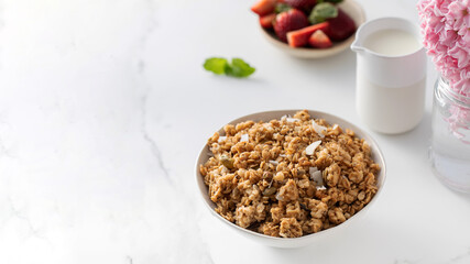 Crispy homemade granola with sliced almonds in a bowl with strawberries. Healthy eating. Copy space