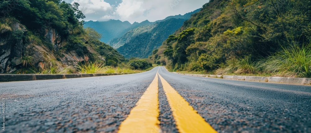 Wall mural Asphalt Road Leading Through Lush Green Mountains