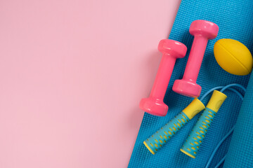 Time for exercising sport equipment on the pink table background, healthy and workout concept