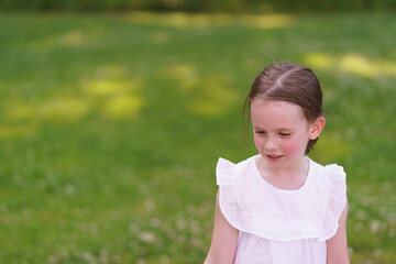 Preschool girl with a missing tooth delighting in playground adventures on a hot day.