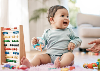 Happy baby, toys and development in living room for growth, learning and hand for support or care. Child, laughing and playing with abacus in home for motor skills and education with parent in lounge