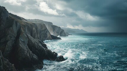 Rugged cliffside overlooking a vast ocean with waves crashing against the rocks beneath a cloudy sky