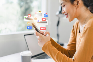 Beautiful young woman enjoy with social media on mobile phone with notification icons of like, message, comment above smartphone screen.