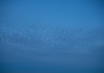 High stationary clouds and lower clouds, moving across the night sky,