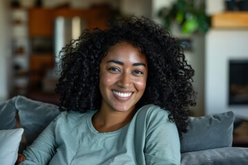 Fototapeta premium Naturally curly hair and broad, gorgeous grin, this beautiful African adolescent girl is posing indoors on a sofa Portrait of Generation Z.