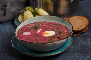 Traditional Belorussian, Latvian, Lithuanian, Polish, Russian and Ukrainian Beetroot cold creamy soup with cucumber, radish, potatoes and egg . Summer soup concept