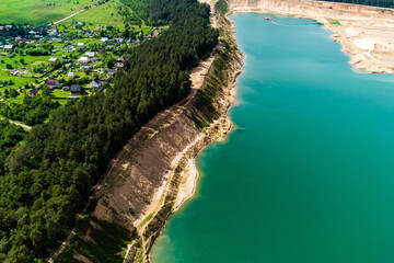 A large flooded sand quarry bordering the village, aerial view. Bolotsky quarry, Kaluga region