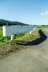 太陽に照らされた、田舎の道のガードレール