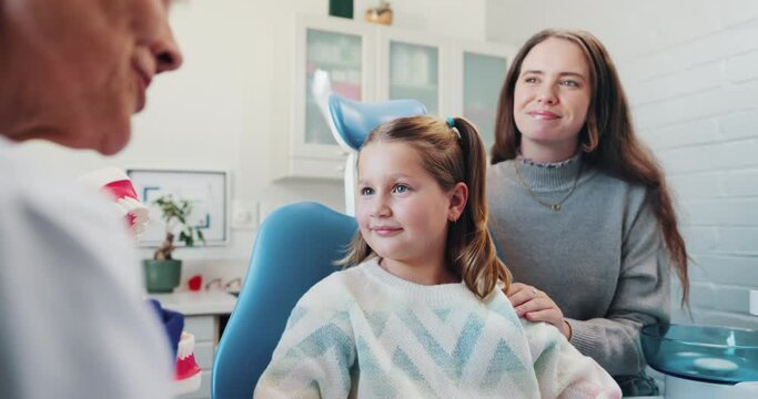 Hospital, pediatric dentist and girl with demonstration, oral education and discussion of surgery. Healthcare, mom and child in orthodontist with dental model, examination and learning for braces
