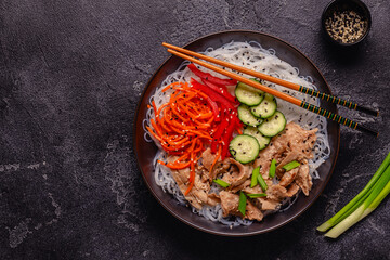Bowl of rice noodles with vegan soy meat and vegetables.