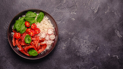 Bowl with vegan fried soy meat and vegetables served with boiled rice.