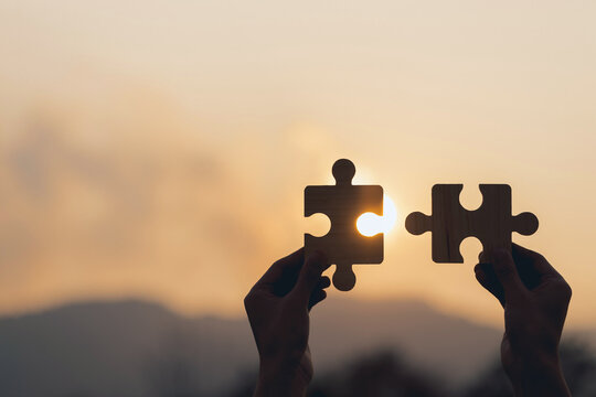  Strategies for business success. Collaboration and teamwork concept.two hands of business to connect a couple of puzzle pieces with sunset. business partnership.Charity, volunteer. Unity,