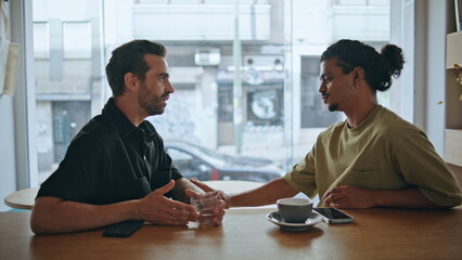 Couple gays relaxed meeting in restaurant close up. Two guys talking smiling
