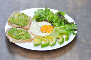 bread with mashed avocado topping ,sunny side up egg with lettuce and avocado for serve