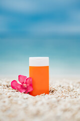 Bright sunscreen bottle on pebble beach with sea as background. Concept of minimalist design of advertisement of sunscreen or cosmetics. Protection against ultraviolet rays or harmful effects of sun