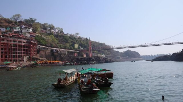 ancient hindu pilgrimage temple at holy river bank with tourist ferry boats at morning