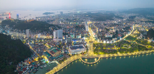 Aerial view of Ha Long cityscape at twilight period in Northern Vietnam. Urban development texture, transport infrastructure. Near Halong Bay. Popular landmark, famous destination of Vietnam.