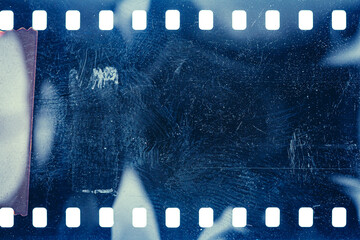 Dusty and grungy 35mm film texture or surface. Perforated scratched camera film isolated on white...