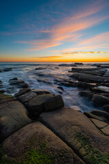 Obraz premium Water flowing around the rocky coastline.