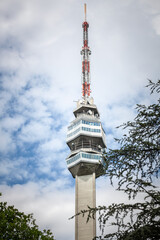 Picture of the Avala tower, or Avala toranj, seen from a nearby forest. It is a TV tower and broadcasting antenna in the suburbs of Belgrade, Serbia.A striking view of Avala Tower, an iconic telecommu