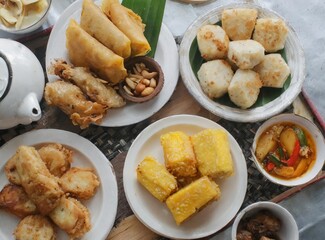 Various fried foods served on plates that are famous in Indonesia, such as corn bakwan