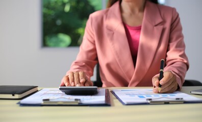 Image of a young Asian female company employee smiling and holding a digital tablet standing on a white background.
