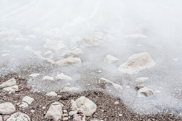 Sand beach with white waves, close-up. Foamy coastline. Seascape for publication, poster, calendar, post, screensaver, wallpaper, postcard, banner, cover, website. High quality photo