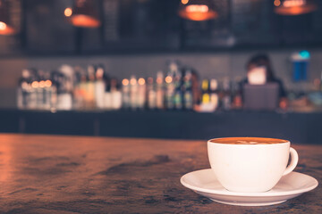 Cup of hot coffee on the table with coffee shop or cafe background in the morning